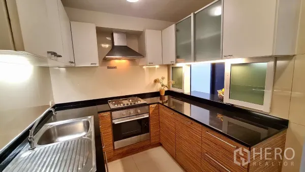房间 出租在Watthana, Bangkok - L型整体厨房，配备烤箱、灶台、抽油烟机及充足柜体