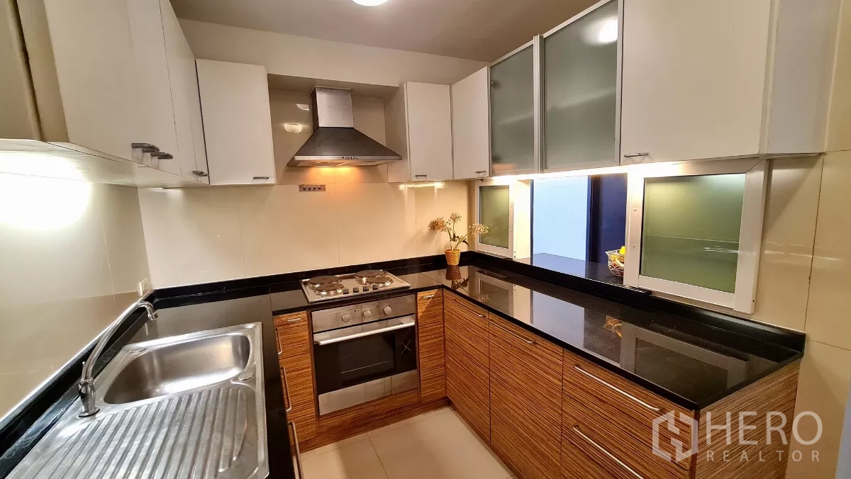 房间 出租在Watthana, Bangkok - L型整体厨房，配备烤箱、灶台、抽油烟机及充足柜体