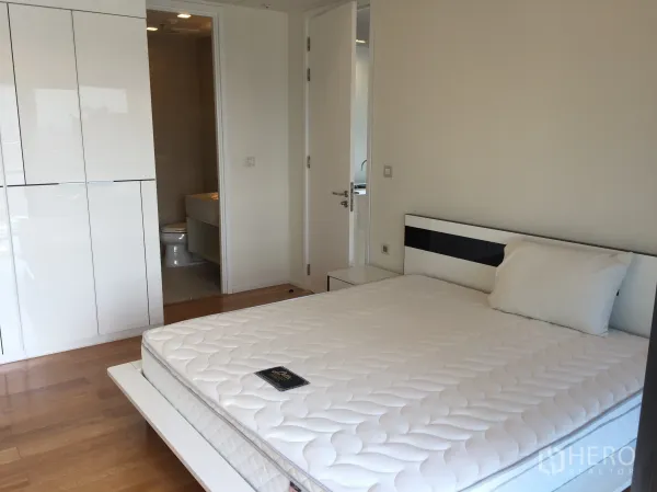Condominium for rent in Ratchathewi, Bangkok - Primary bedroom with built-in wardrobe, wood flooring, and an ensuite bathroom.
