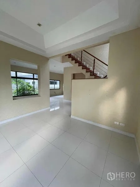 独立式住宅 出售在Lat Krabang, Bangkok - 入户挑高空间，设大窗与通往二层的木楼梯。