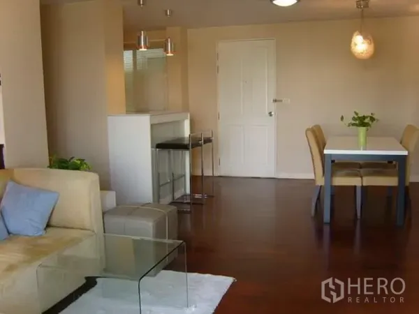 Condominium for rent in Watthana, Bangkok - Open-plan living and dining area with breakfast bar and warm wooden floors.