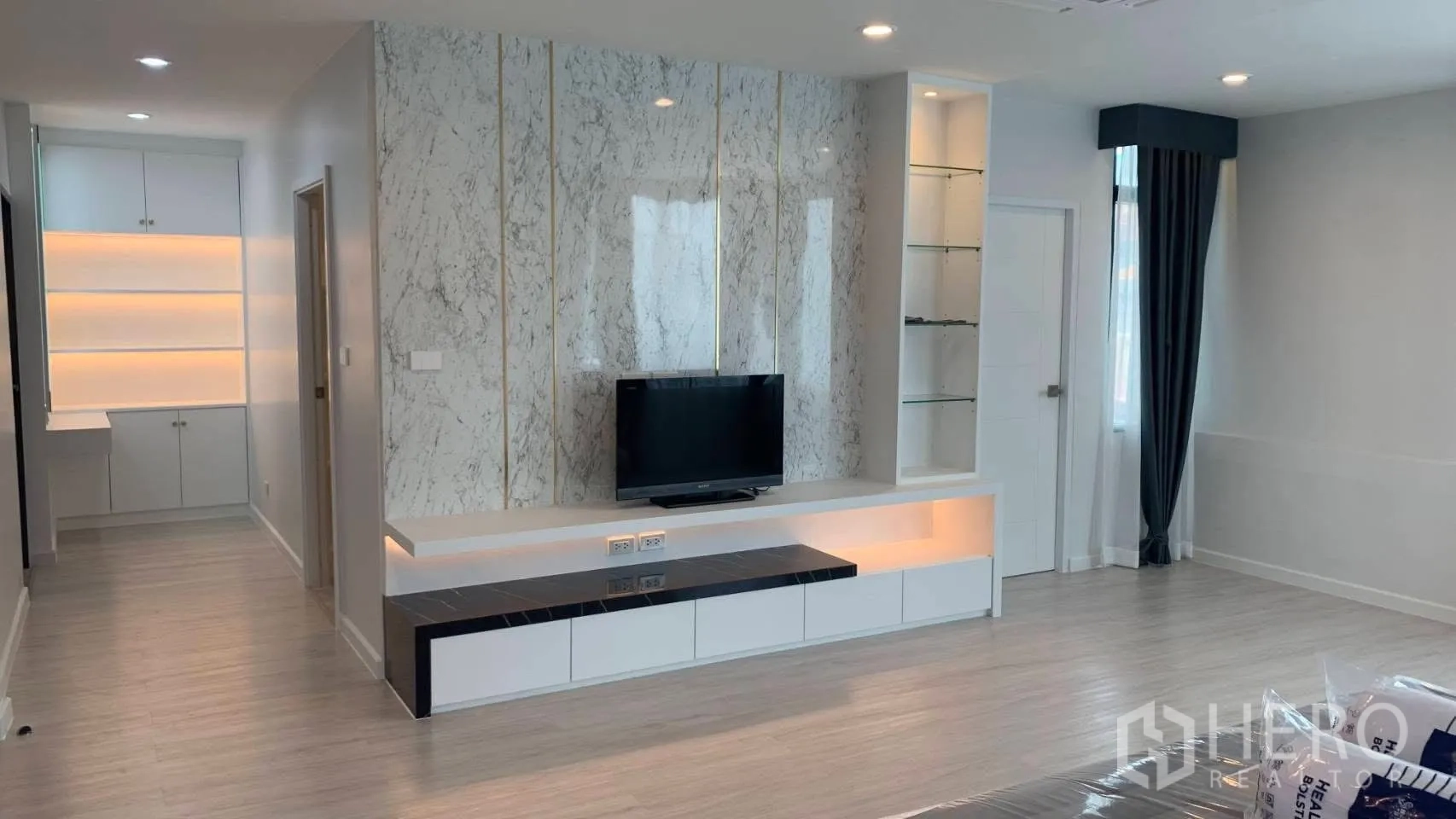 Detached House for rent in Lat Phrao, Bangkok - Bedroom lounge with built-in TV wall and storage cabinets.