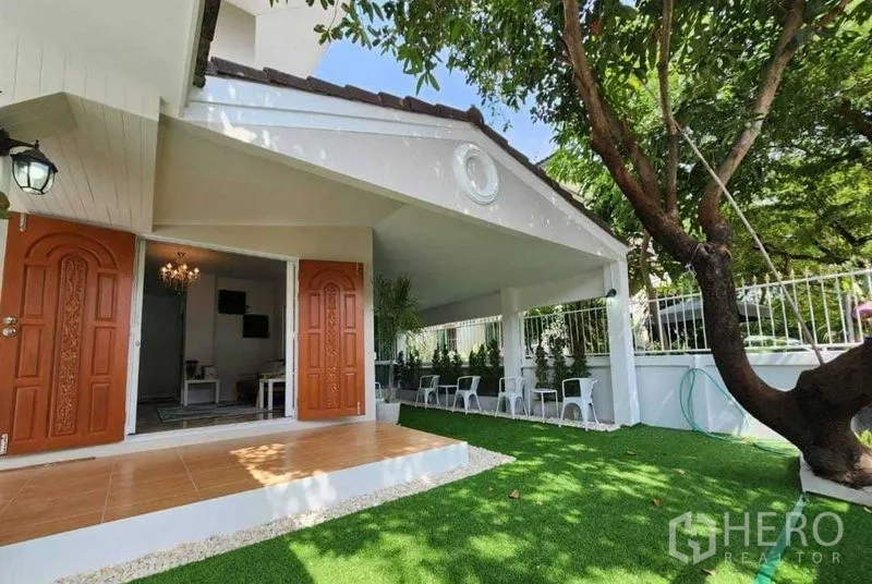 Detached House for rent in Lam Luk Ka, Pathum Thani - Front terrace and lawn shaded by a mature tree beside the house.