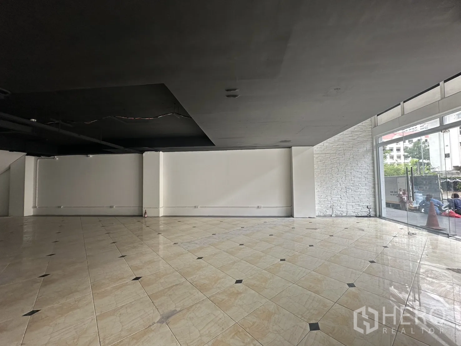 Retail Space for rent in Pathum Wan, Bangkok - Open-plan shop floor with floor-to-ceiling windows and a white brick accent wall.