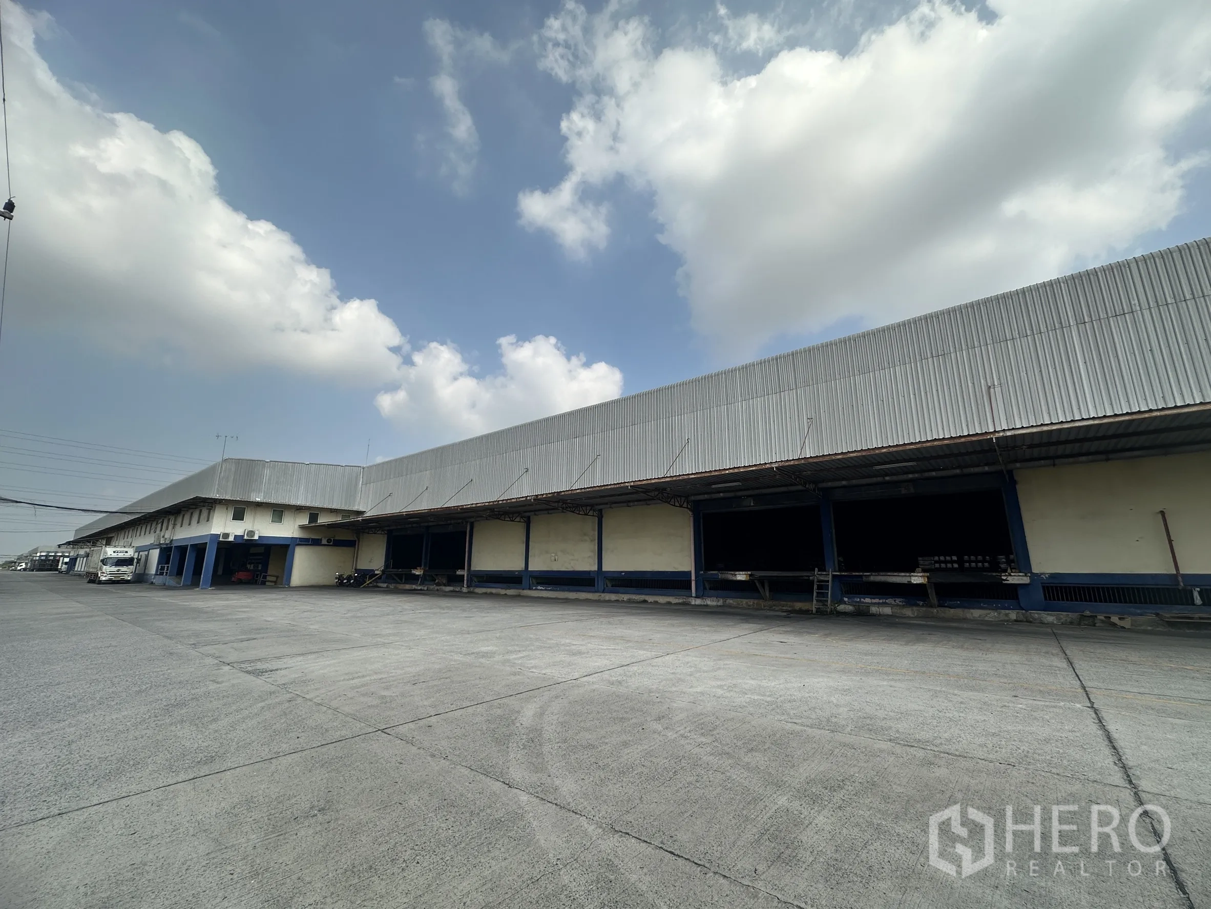 Warehouse for rent in Bang Pa-in, Phra Nakhon Si Ayutthaya - Warehouse exterior with long covered loading bays and a wide concrete truck yard.