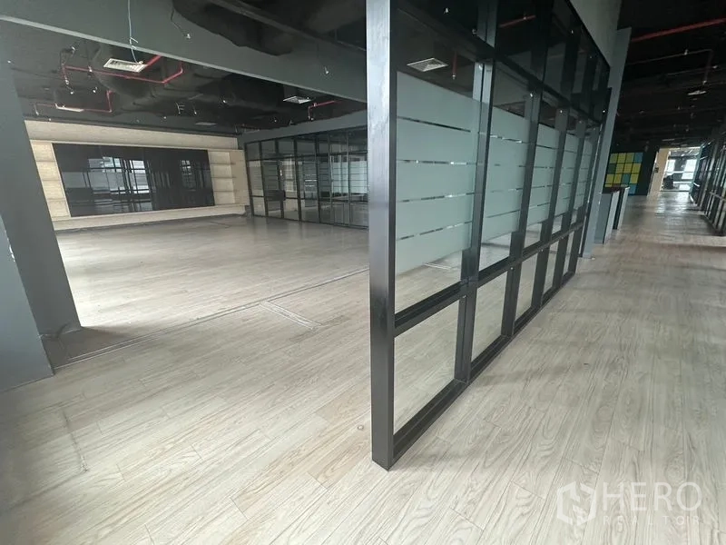 Office Space for rent in Bang Rak, Bangkok - Corner view showing glass panels connecting two adjoining open work areas.