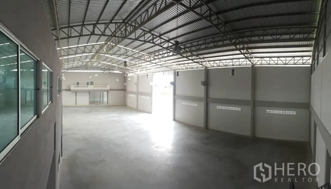 Factory for rent or sale in Bang Sao Thong, Samut Prakan - Warehouse aisle view showing arched steel roof and ventilation blocks.