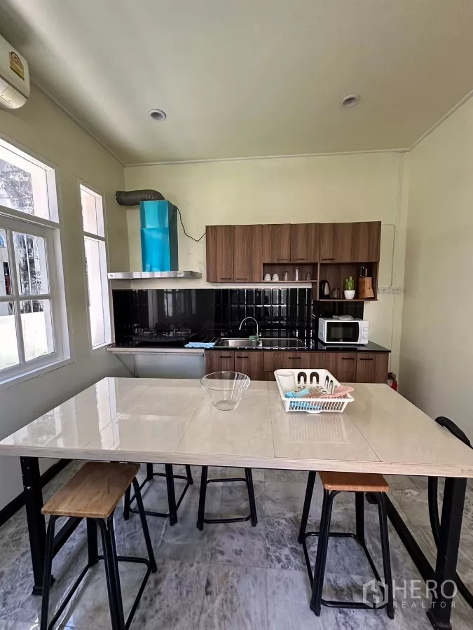 带办公室的家 出租在Suan Luang, Bangkok - 采光良好的厨房，早餐岛台与蓝色油烟机。