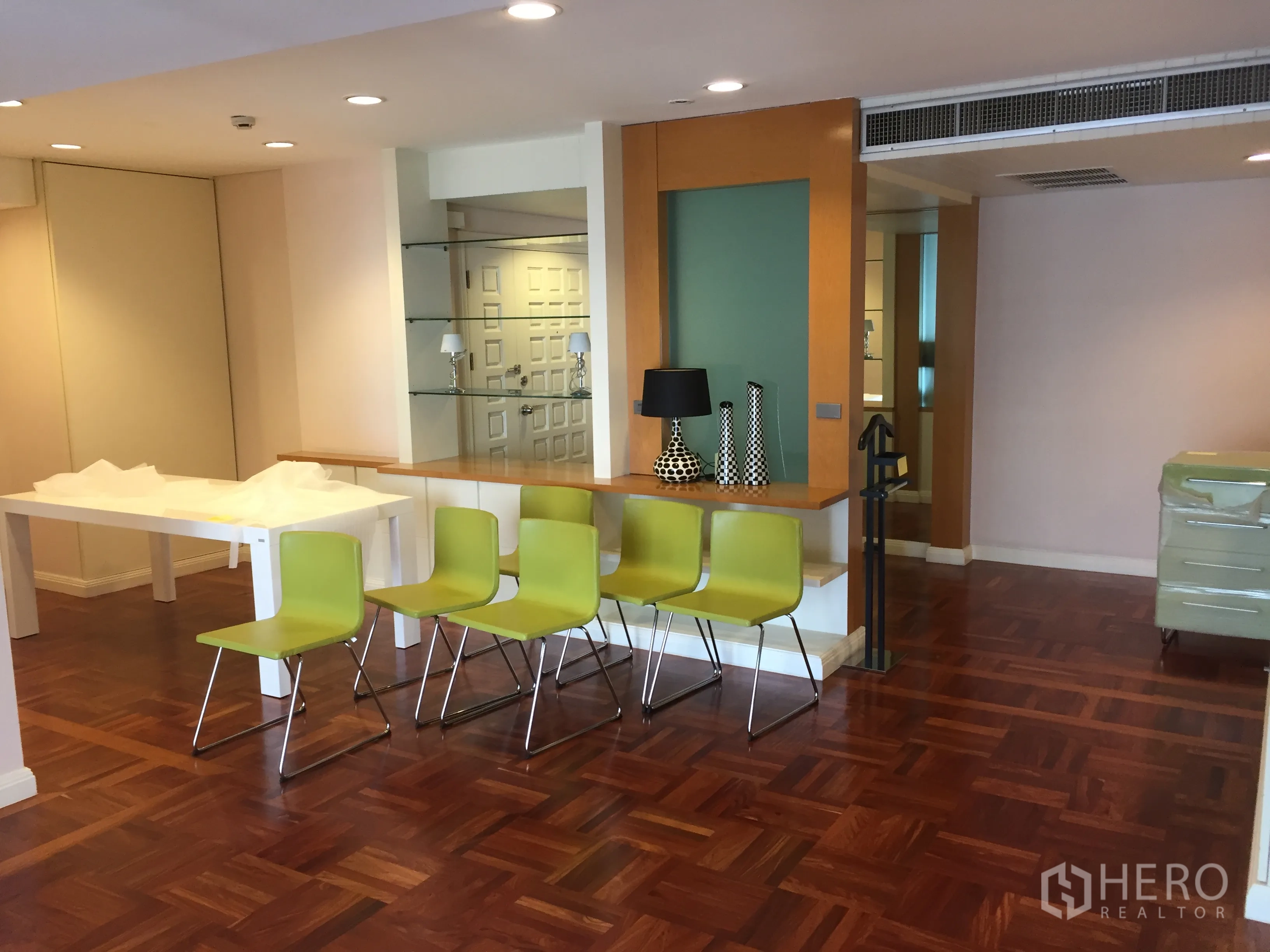 公寓 出租在Pathum Wan, Bangkok - 开放式客餐厅，拼花木地板，吧台与筒灯照明。
