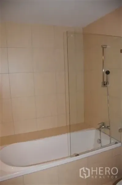 Condominium for rent in Khlong Toei, Bangkok - Bathroom featuring a bathtub, handheld shower and clear glass screen.