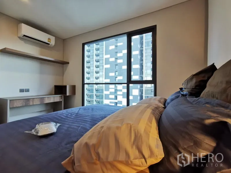 คอนโด ให้เช่าในRatchathewi, Bangkok - ห้องนอนพร้อมหน้าต่างบานใหญ่ โต๊ะทำงาน ชั้นวาง และเครื่องปรับอากาศ วิวเมือง