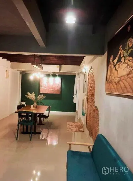 บ้าน ให้เช่าในPathum Wan, Bangkok - โถงนั่งเล่นเชื่อมทานอาหาร พื้นเงางาม โซฟาสีเขียว และผนังอิฐโชว์