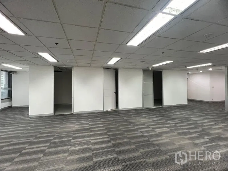 Office Space for rent in Khlong Toei, Bangkok - Open office with sliding doors to storage or meeting rooms and grid ceiling lights.