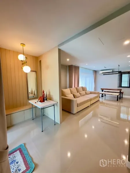 บ้าน ให้เช่าในSamut Prakan - โถงนั่งเล่นและรับประทานอาหารแบบเปิดโล่ง โซฟาสีครีมและไฟแขวนสวยงาม