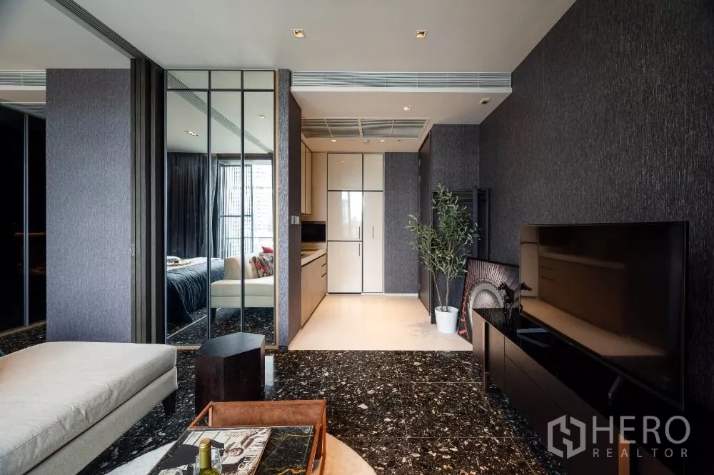 Condominium for rent or sale in Khlong Toei, Bangkok - Living area looking toward the kitchenette, TV unit and indoor plant.