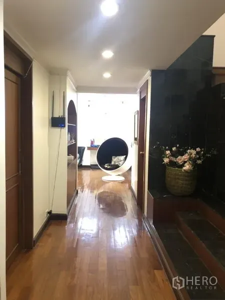 Condominium for sale in Watthana, Bangkok - Corridor leading to the living area with spotlight ceiling and built-in display shelving.