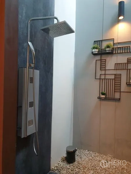 独立式住宅 出售在Watthana, Bangkok - 户外雨淋花洒，卵石地面与装饰置物架。