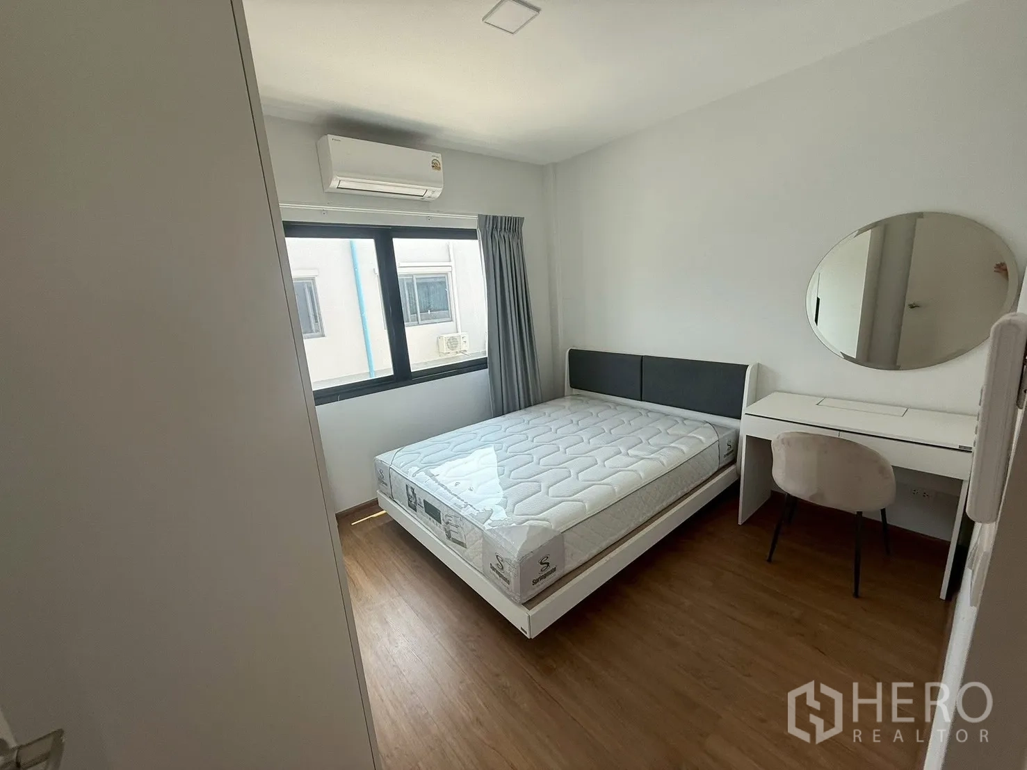 联排别墅 for rent in Bang Phli, Samut Prakan - 卧室内设书桌、圆形镜子、床与窗式空调。