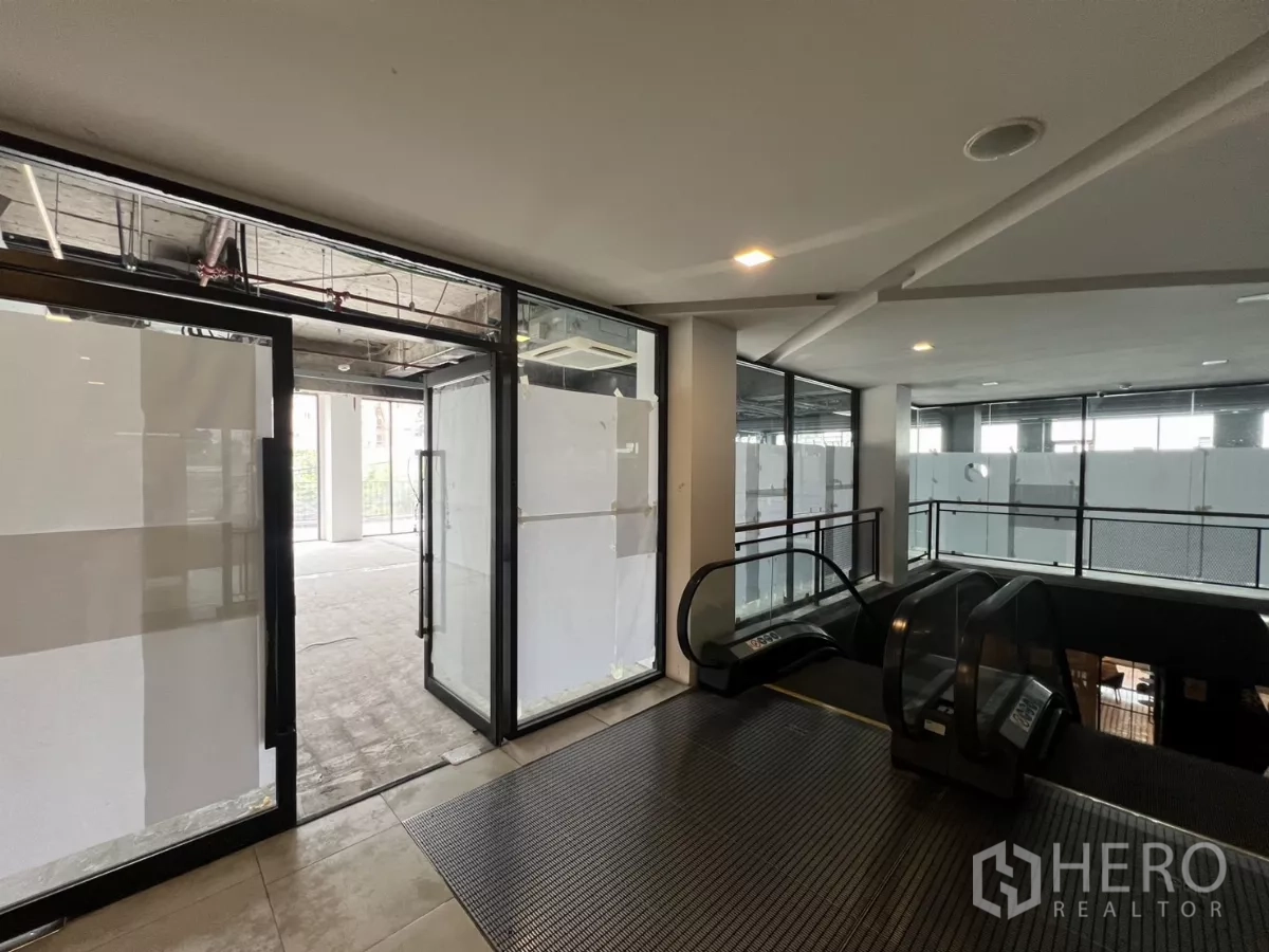 Retail Space for rent in Watthana, Bangkok - Second-floor retail entrance with escalator access and glass storefront doors.