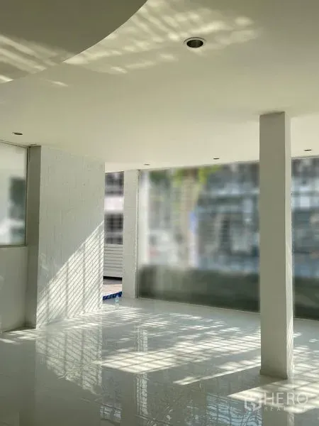 店屋 出租在Dusit, Bangkok - 明亮的开放式室内空间，白色亮面地砖、立柱与落地窗。