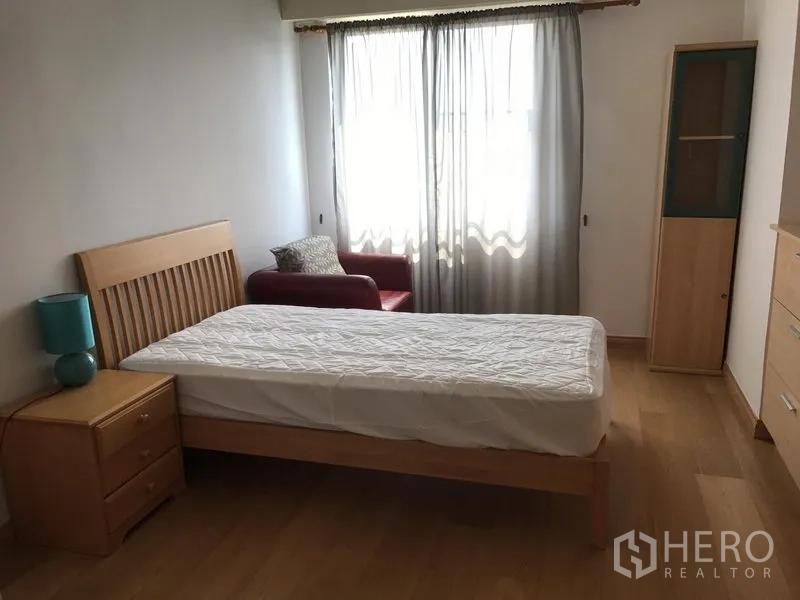 公寓 出租在Watthana, Bangkok - 宽敞卧室，单人床、窗边沙发与收纳柜。