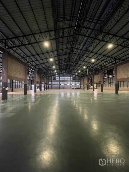Warehouse for rent in Si Racha, Chon Buri - Clear-span warehouse hall with high ceilings and bright industrial lighting.