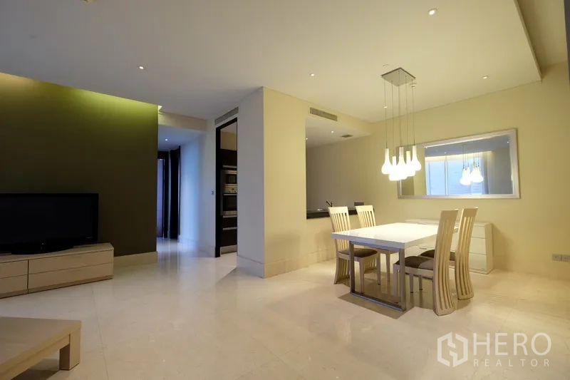 Condominium for rent in Bang Rak, Bangkok - Open-plan living and dining space with TV cabinet and statement lighting.