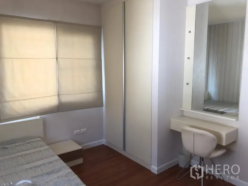 Detached House for rent in Bang Kapi, Bangkok - Bedroom corner with built-in wardrobe, vanity and soft fabric blinds.