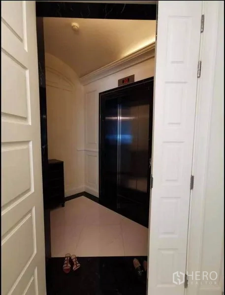 Condominium for rent in Watthana, Bangkok - Private lift lobby with black elevator doors and white paneled walls.