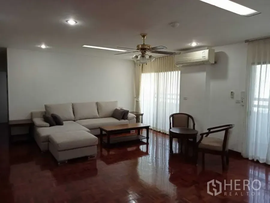 คอนโด ให้เช่าในWatthana, Bangkok - ห้องนั่งเล่นอีกมุม โซฟาเข้ามุม โต๊ะกลาง พัดลมเพดาน และเครื่องปรับอากาศ