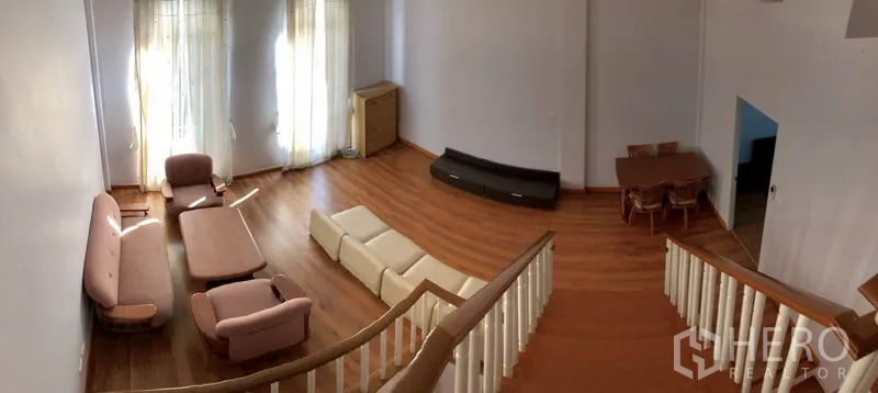 Townhouse for rent in Yan Nawa, Bangkok - Upper‑floor family room with wood flooring and multiple sofas.