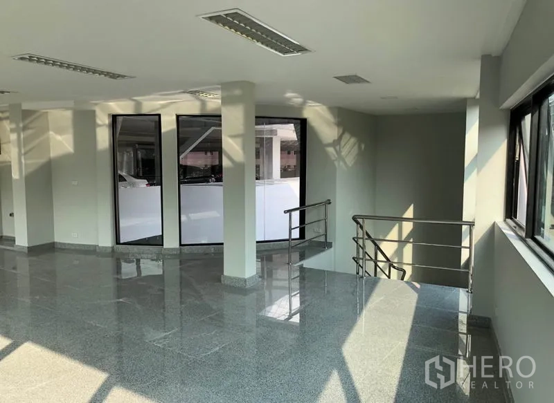 Office Space for rent in Khlong Toei, Bangkok - Upper-floor office area with expansive windows and a corner railing.
