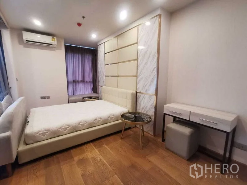 Condominium for rent in Ratchathewi, Bangkok - Bedroom with upholstered bed, vanity desk and wood floors.