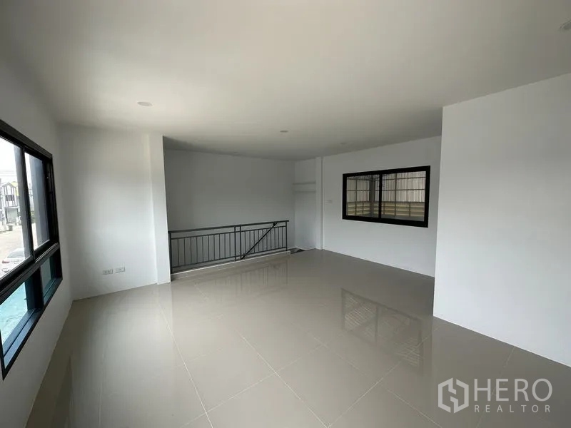 Factory for rent or sale in Bang Yai, Nonthaburi - Upper floor office with glossy tiles, large windows and stair balustrade.