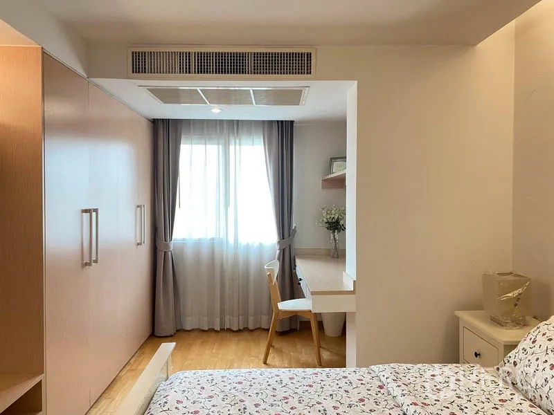 公寓 出租在Phra Khanong, Bangkok - 卧室配到顶衣柜及窗边小型工作区，木地板。