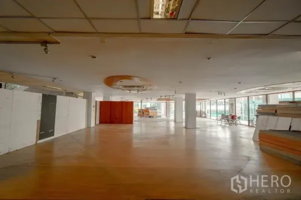 Retail Space for rent in Watthana, Bangkok - Large retail floor with circular ceiling detail, timber flooring and wraparound glazing.