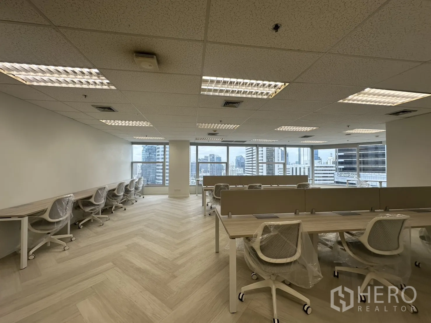 办公室 for rent in Sathon, Bangkok - 宽敞协作区成排工位，通过大面积玻璃欣赏城市景观。