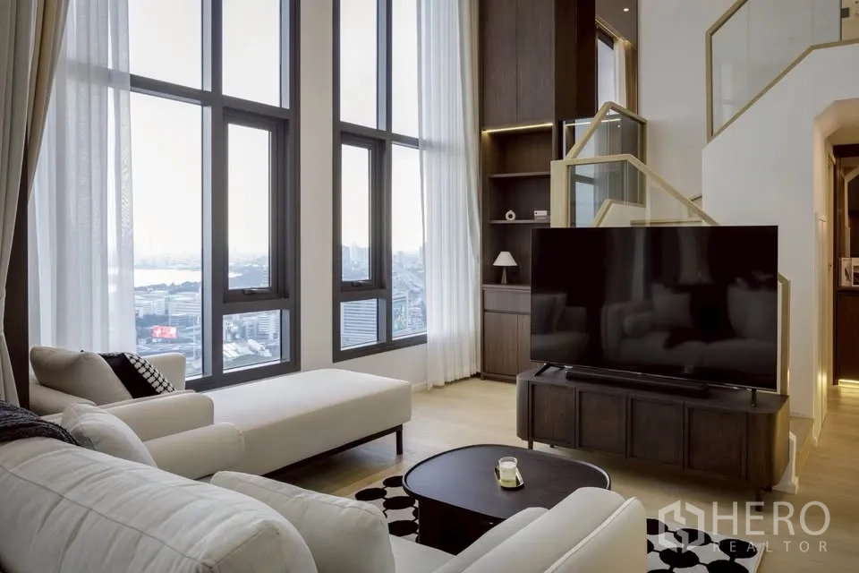 คอนโด for rent in Khlong Toei, Bangkok - มุมนั่งพักผ่อนมีเดย์เบดหันเข้าหาทีวีขนาดใหญ่ รายล้อมด้วยหน้าต่างสูง
