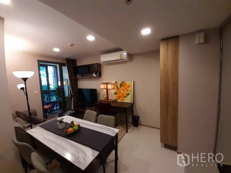 公寓 出租或出售在Watthana, Bangkok - 餐区设大理石纹餐桌与六把椅子，连通客厅与阳台。