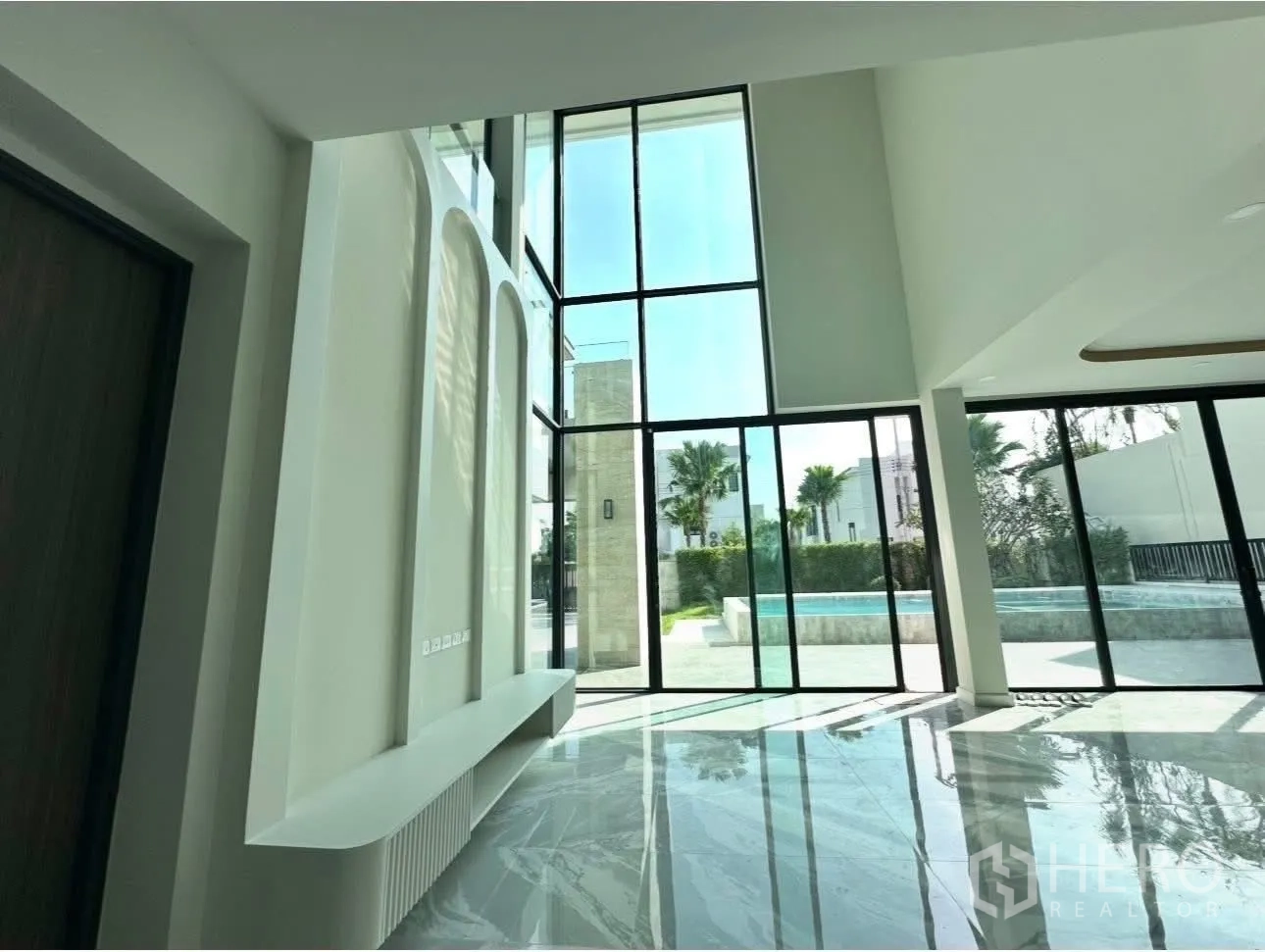 บ้านเดี่ยว for sale in Bang Khen, Bangkok - พื้นที่นั่งเล่นเปิดสู่ระเบียงสระด้วยประตูกระจกบานเลื่อนขนาดใหญ่