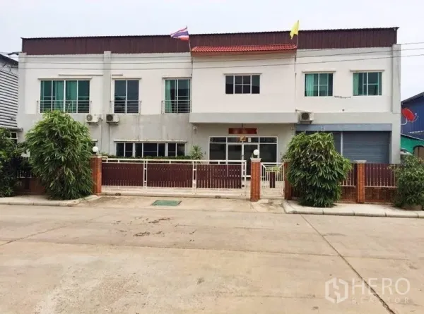 Warehouse for sale in Mueang Samut Sakhon, Samut Sakhon - Front view of a two-storey warehouse with gated entrance and parking in Mueang Samut Sakhon.