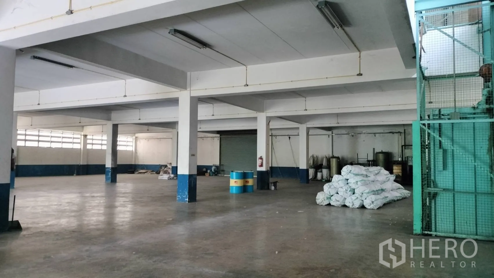 โรงงาน for rent in Lat Krabang, Bangkok - คลังสินค้าพื้นที่โล่ง มีเสารองรับ ช่องแสงยาว และกระสอบวางบนพื้นคอนกรีต.