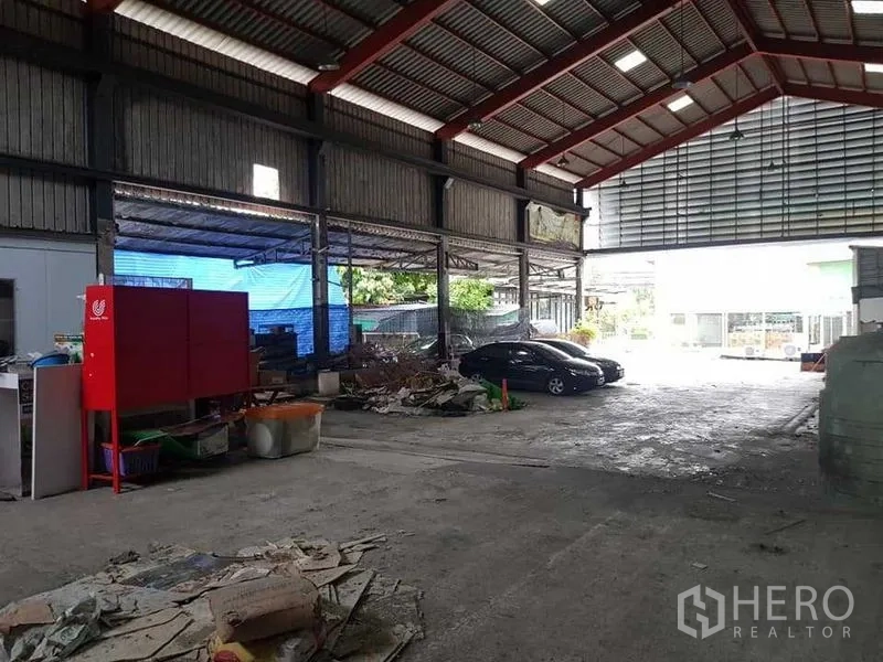 货栈 出租在Thung Khru, Bangkok - 仓库作业区，红色设备柜、杂物与开放侧廊。
