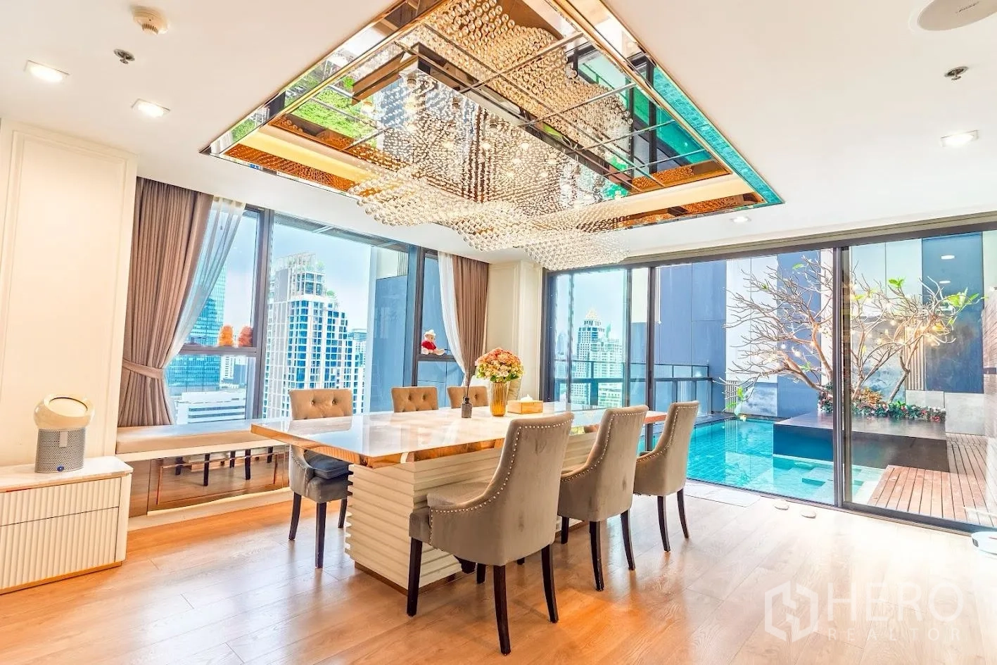 Condominium for sale in Sathon, Bangkok - Dining room with crystal chandelier opening to a private pool terrace and skyline.