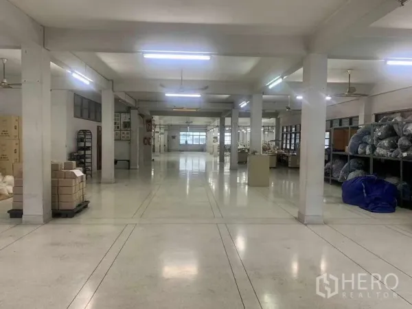 Office Space for rent in Khlong San, Bangkok - Spacious open-plan office floor with columns, bright fluorescent lighting and storage racks.