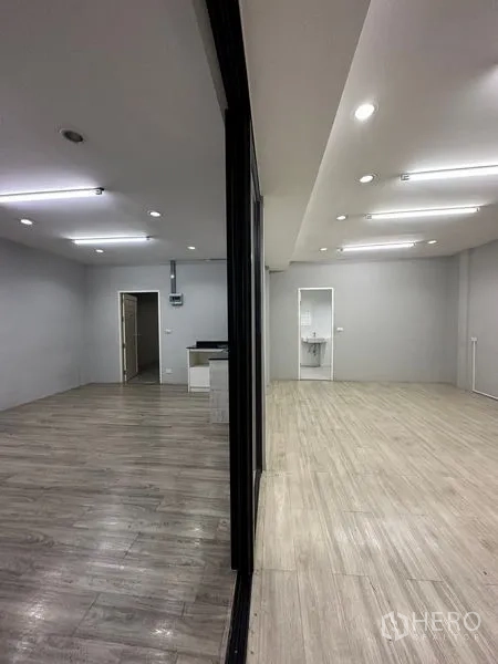 零售空间 出租在Khlong Toei, Bangkok - 透过玻璃隔断可见两侧分区，天花LED灯与独立洗手池。