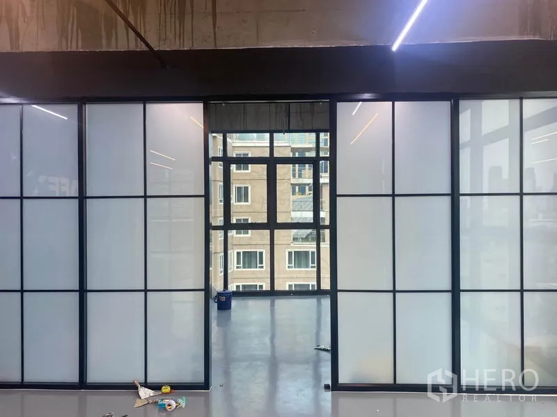 办公空间 出租在Khlong Toei, Bangkok - 可滑动的磨砂玻璃隔断，将空间分成会议室，尽头为面向城市的窗户。