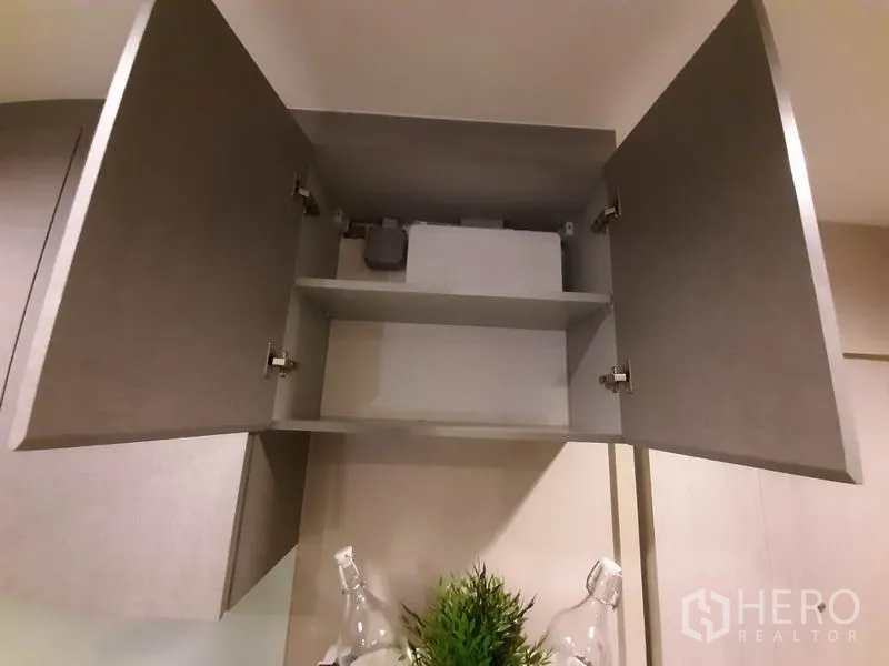 Condominium for rent or sale in Khlong Toei, Bangkok - Overhead cabinet interior above the refrigerator for extra storage.