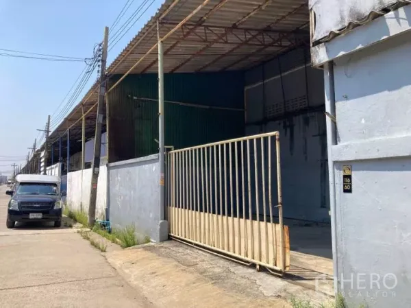 Factory for rent in Bang Sao Thong, Samut Prakan - Street-side view of warehouse row with gated entrance and parking area.