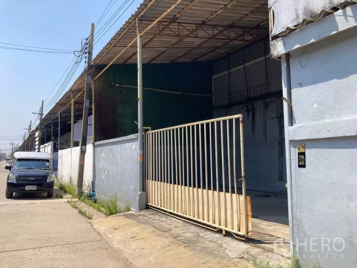 Factory for rent in Bang Sao Thong, Samut Prakan - Street-side view of warehouse row with gated entrance and parking area.